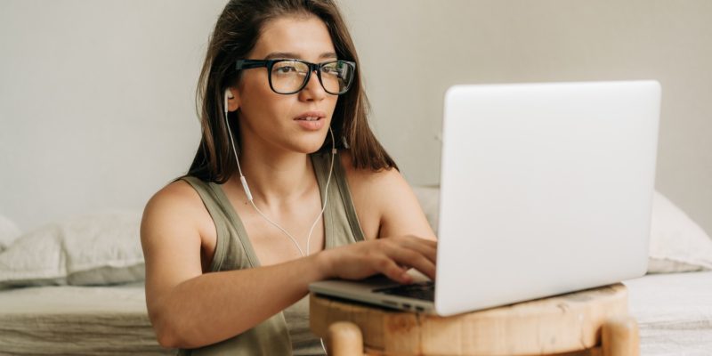 Young female student studying using laptop and headphones. Young female student studying using laptop and headphones.