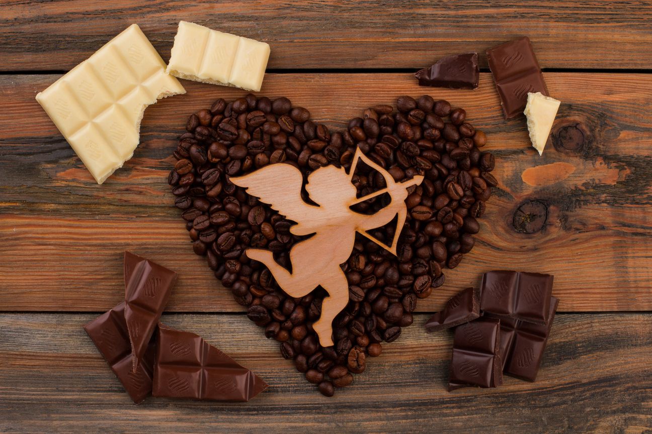 Heart shaped coffee beans and wooden cupid.